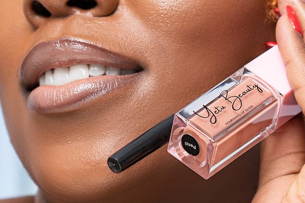 Wahu Muchai holding lip gloss on her cheeks